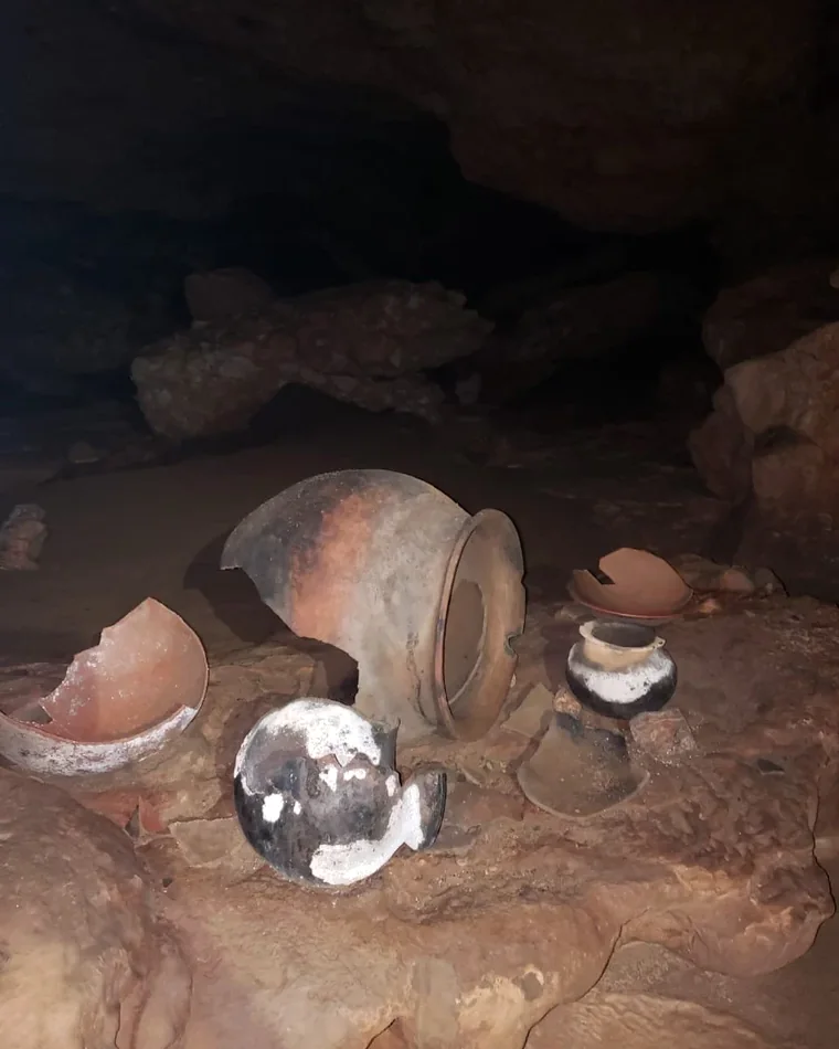Ancient Maya ceramic vessels resting inside ATM Cave